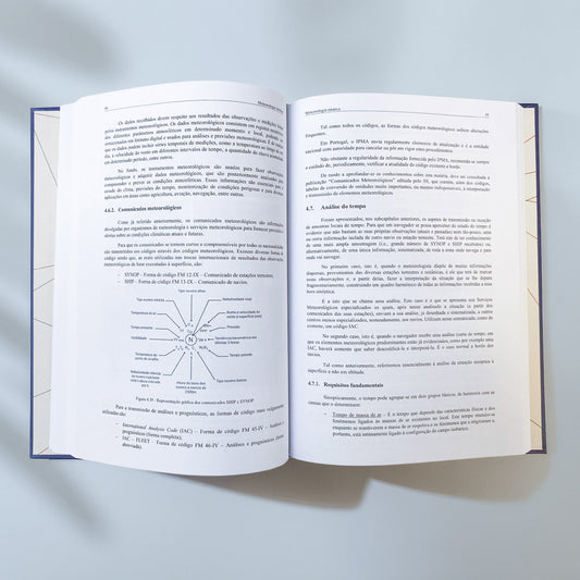 Vista do livro Manual de Navegação Vol I aberto mostrando diagramas técnicos e páginas impressas.