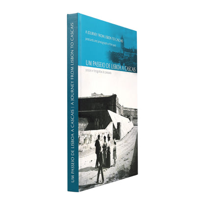 Vista de perfil do livro "Um Passeio de Lisboa a Cascais", destacando a lombada azul e a qualidade da encadernação.