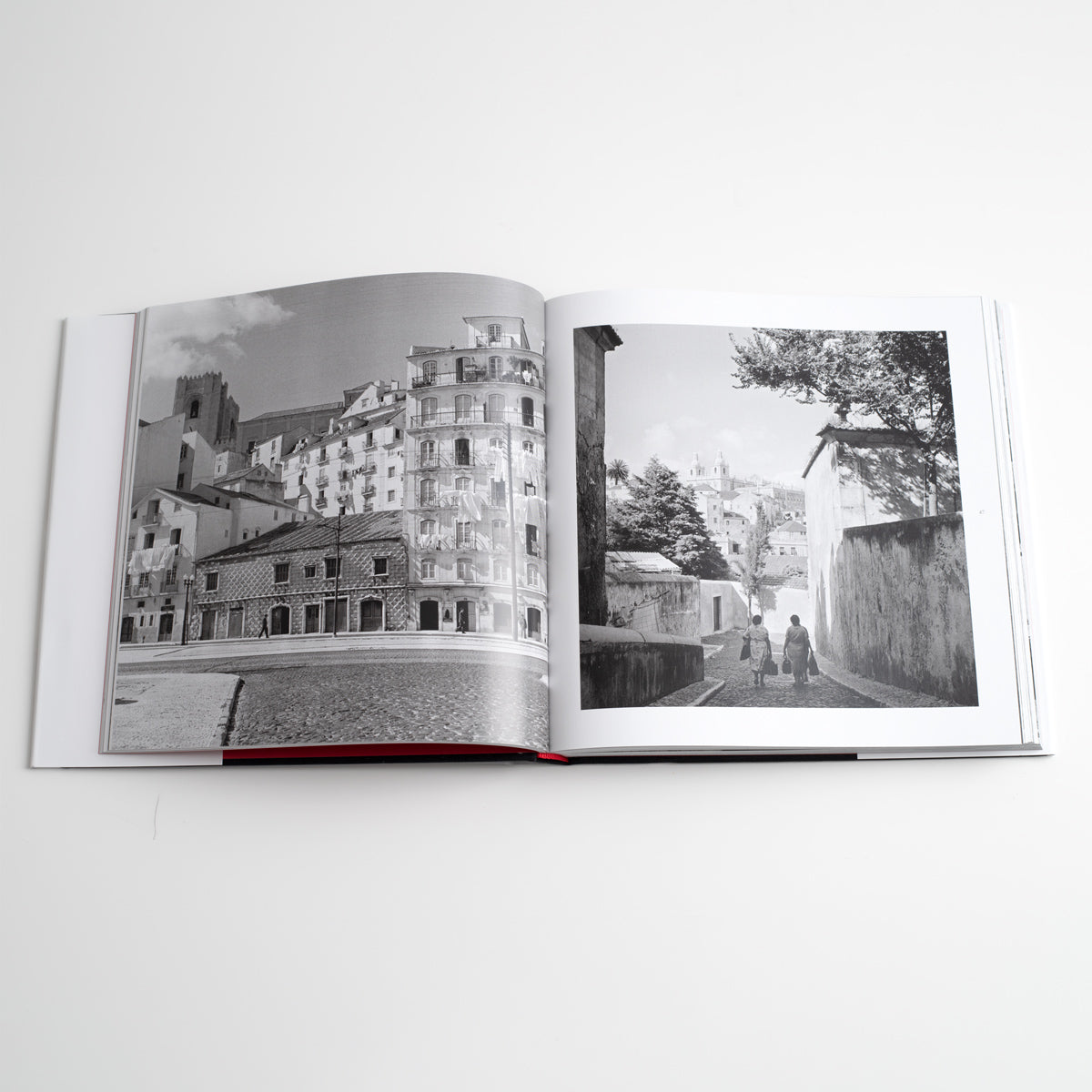 Interior do livro aberto mostrando o design de paginação limpo com fotografias a preto e branco capturando feiras tradicionais e pessoas em mercados de época.