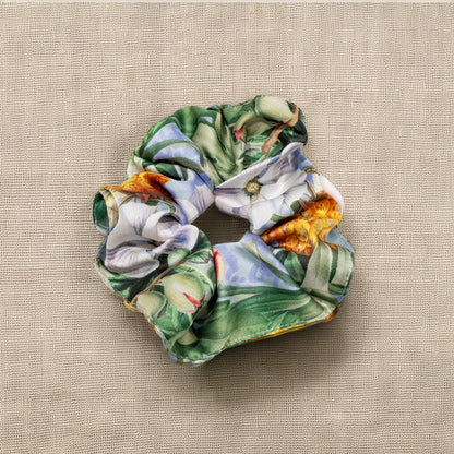 Elástico de cabelo scrunchie azul com padrão botânico de ananases e flores tropicais, design Ineditdesign.
