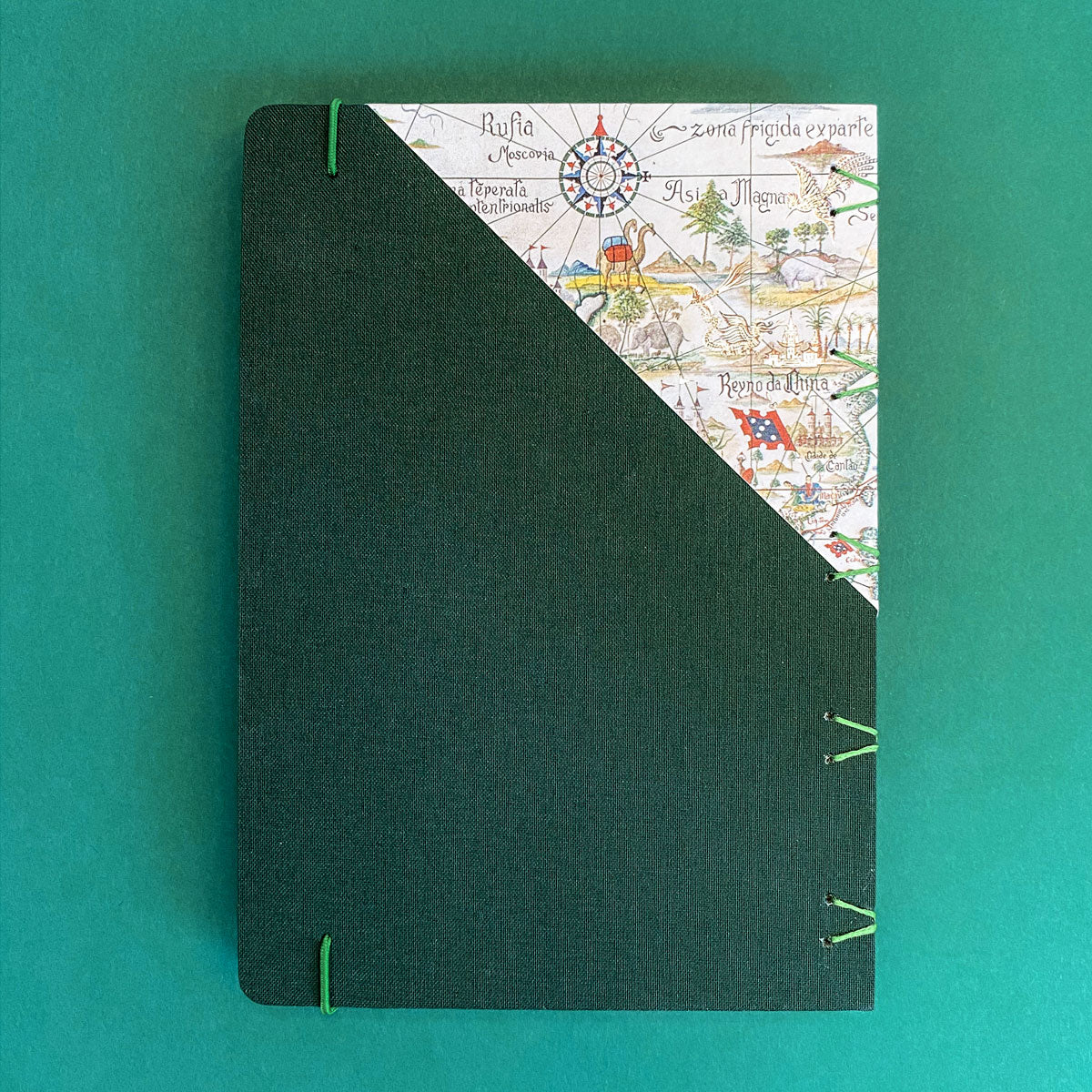 Caderno artesanal Papefolia com capa ilustrada com o Mapa das Explorações Marítimas Portuguesas da entrada do Museu de Marinha, mostrando a cinta oficial de edição exclusiva.