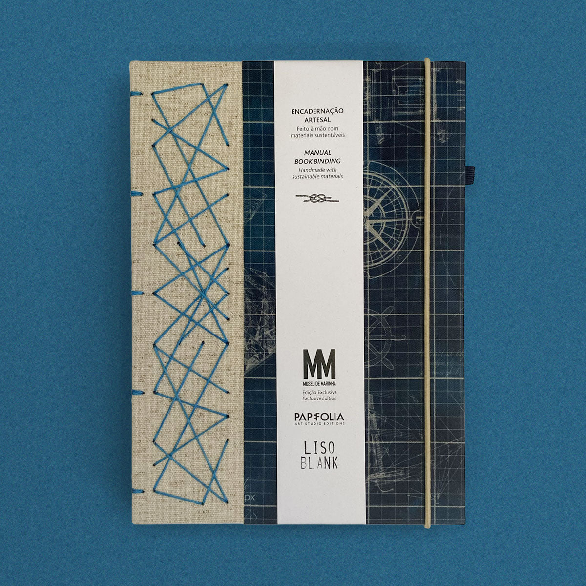 Caderno artesanal com capa em tons de azul e bege com padrões geométricos e linhas náuticas, exibindo a cinta oficial da Papefolia e do Museu de Marinha.