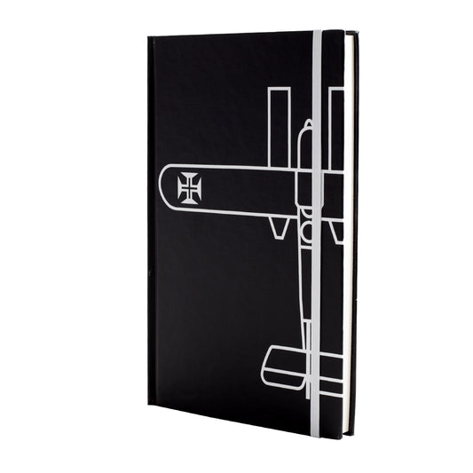 Caderno de capa dura preta tamanho A5 com desenho minimalista em linhas brancas do Hidroavião Santa Cruz de Gago Coutinho e elástico de fecho vertical branco.