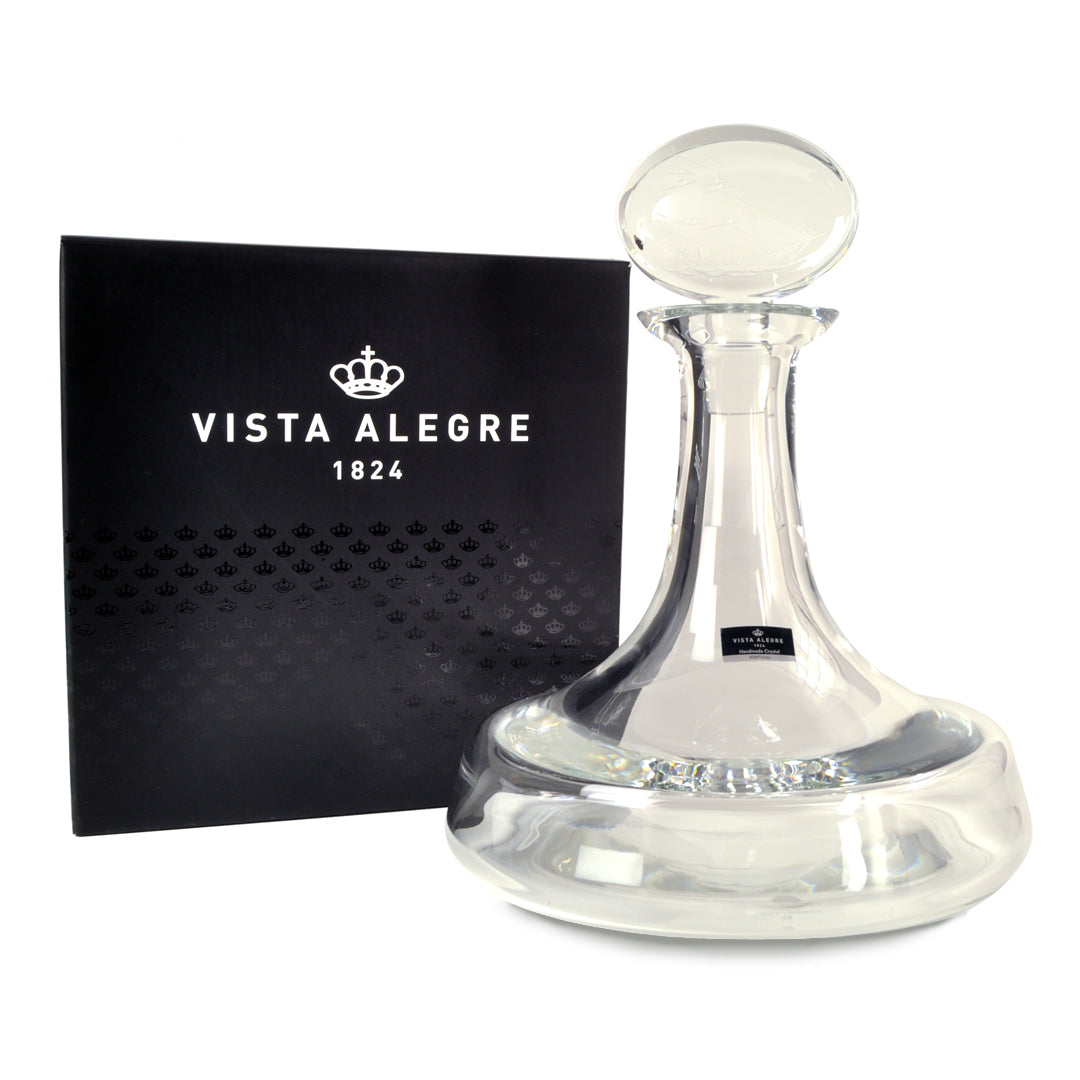 vista  com caixa de Garrafa Clipper da Vista Alegre em vidro transparente, reinterpretando a histórica garrafa de Vinho do Porto do século XVIII com base larga, pescoço curto e design naval.