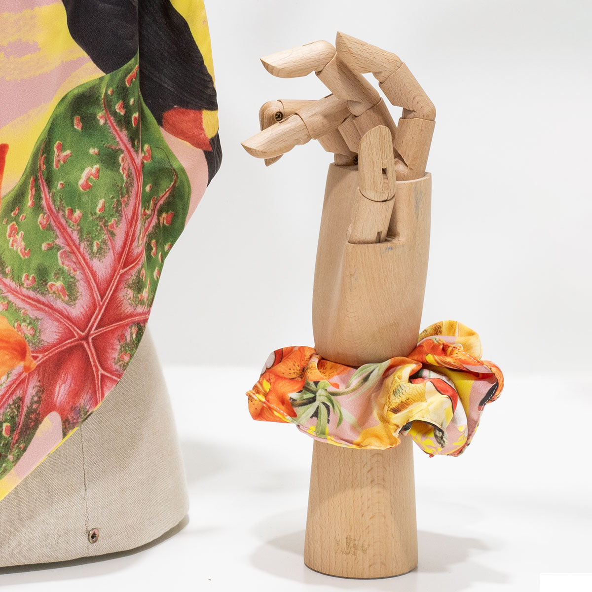 Elástico de cabelo scrunchie amarelo com padrão tropical de tucano e cajus, coleção Viagens Philosophicas do Museu de Marinha.