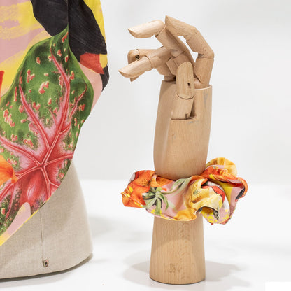Elástico de cabelo scrunchie amarelo com padrão tropical de tucano e cajus, coleção Viagens Philosophicas do Museu de Marinha.
